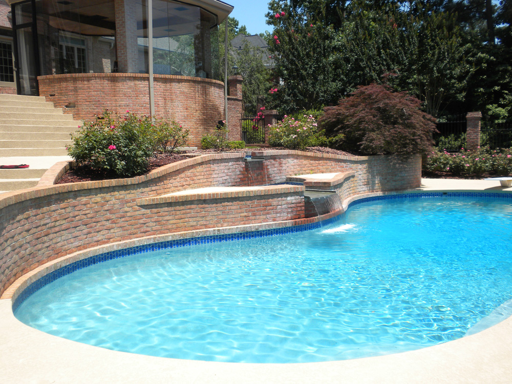 Opulent Pools project with a curved brick wall, waterfall and blue pool water