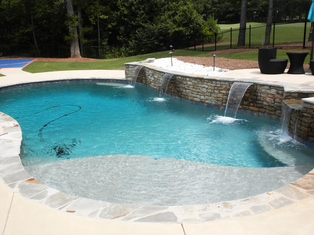 Freeform pool with stacked-stone wall and three sheet waterfalls